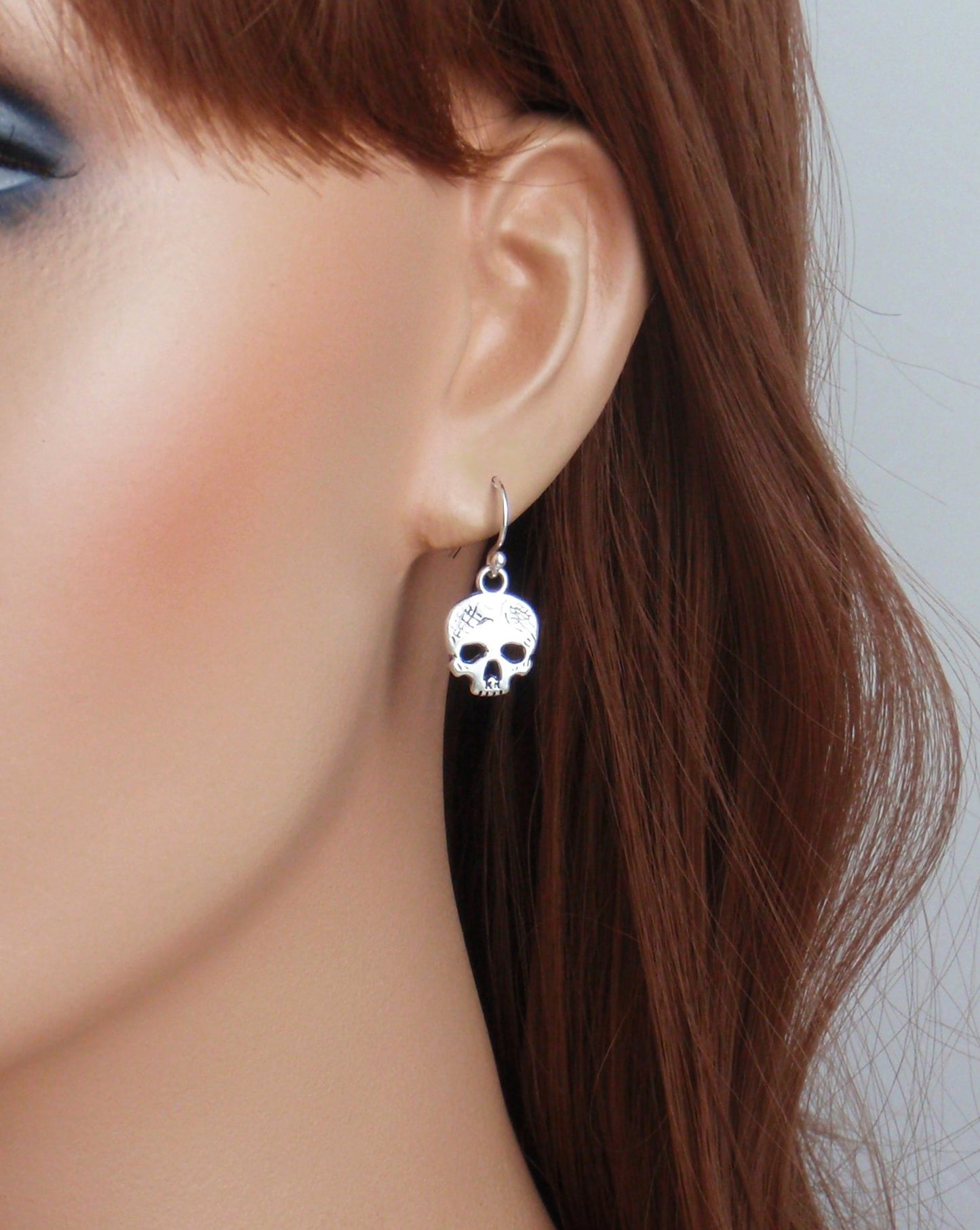 Dainty skull earrings with your choice of 925 sterling silver, stainless steel or titanium earposts. Halloween earrings, small tiny silver